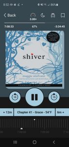 An audiobook screen, showing the book cover of Shiver by Maggie Stiefvater, plus the audiobook controls, including the play button, skip forward/backward buttons, controls for the speed, sleep timer, and the bookmark button..